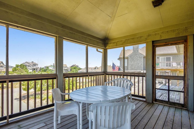 Your screened porch invites leisurely meals with neighborhood views. Enjoy morning coffee or evening dinners surrounded by natural light and coastal breezes, blending indoor comfort with outdoor ambiance.