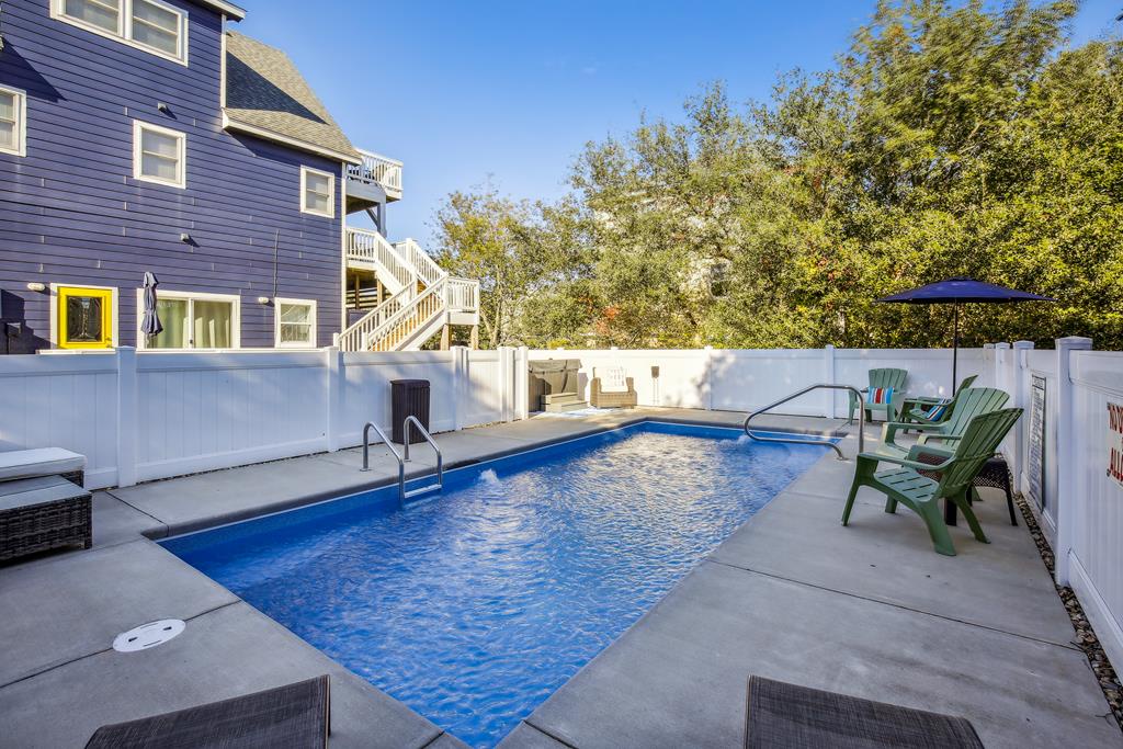Your private pool awaits, surrounded by lounge chairs and umbrellas for sunny afternoons. The spacious deck offers plenty of room to relax and soak up the coastal charm.
