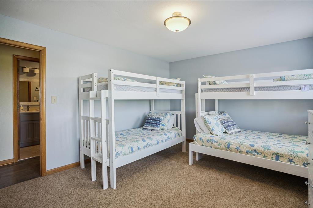 Your family's home base: two bunk beds dressed in cheerful coastal prints, with an ensuite bathroom just steps away for easy mornings.