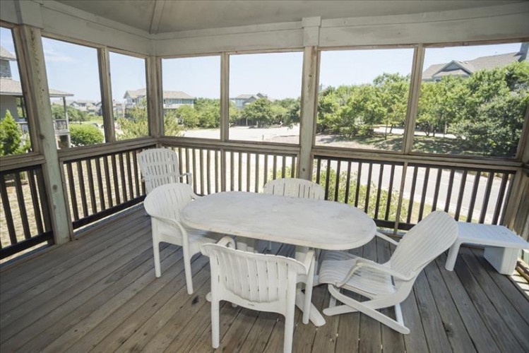 Step onto your screened porch with panoramic views of lush greenery and neighboring rooftops—a perfect spot for morning coffee or sunset dining in complete comfort.