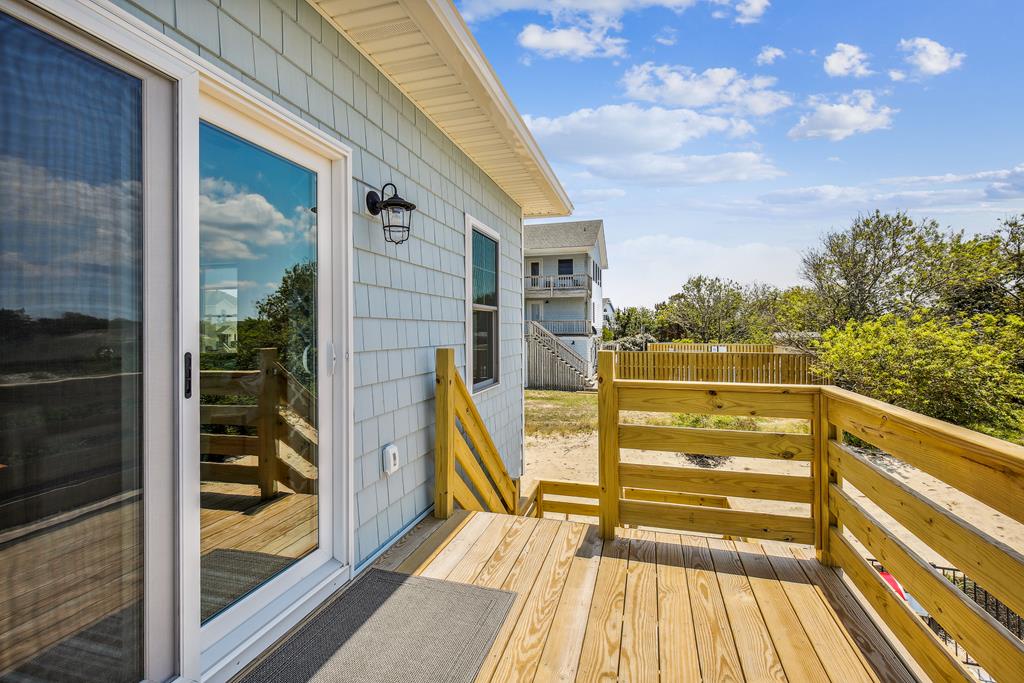 A bright coastal deck provides a peaceful outdoor retreat surrounded by lush greenery and open skies, perfect for morning coffee or sunset relaxation in the fresh ocean breeze.