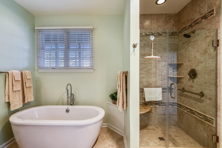 Unwind in your elegant private bathroom, featuring a luxurious soaking tub and a spacious walk-in shower with stylish tiling and modern fixtures for your ultimate relaxation.