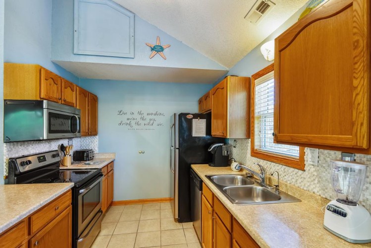 Your fully-equipped kitchen invites you to prepare meals with ease, featuring warm wood cabinetry, modern appliances, and plenty of counter space for all your culinary adventures.