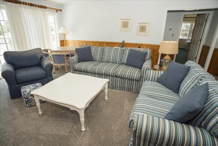 Sink into comfy sofas after beach adventures. Natural light fills your living area where you can unwind with loved ones in this welcoming coastal-themed space.