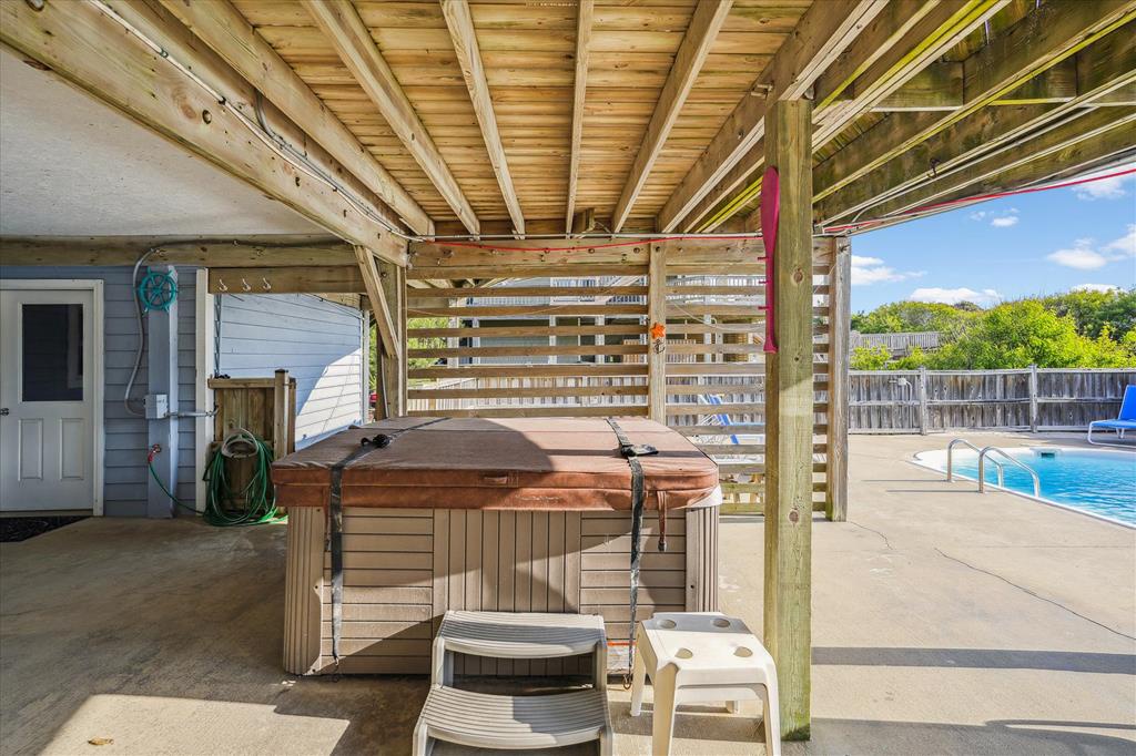 Unwind in your private covered hot tub area, perfectly positioned to overlook the sparkling pool and sunny backyard—ideal for relaxing after a day of exploring.