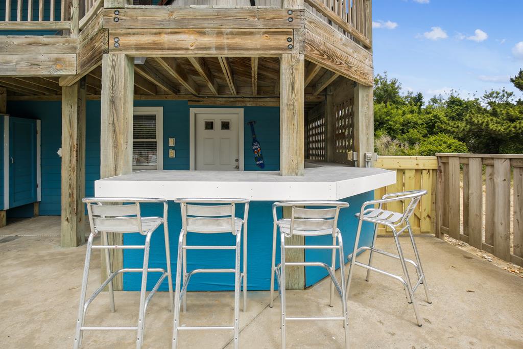 Your private outdoor bar awaits, perfect for sunset cocktails and lively conversations under the coastal sky, just steps from your beach retreat.
