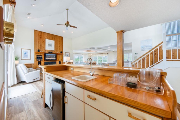 You'll love the open flow between your fully equipped kitchen and cozy living space—perfect for gathering with loved ones while preparing meals on warm wood countertops.