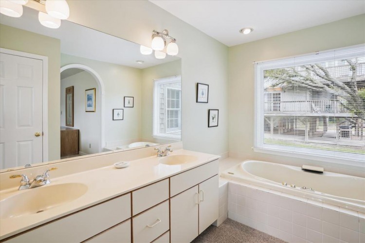 Unwind in your spacious bathroom with dual sinks, a soaking tub, and natural light streaming in—perfect for starting your day refreshed or winding down after exploring.
