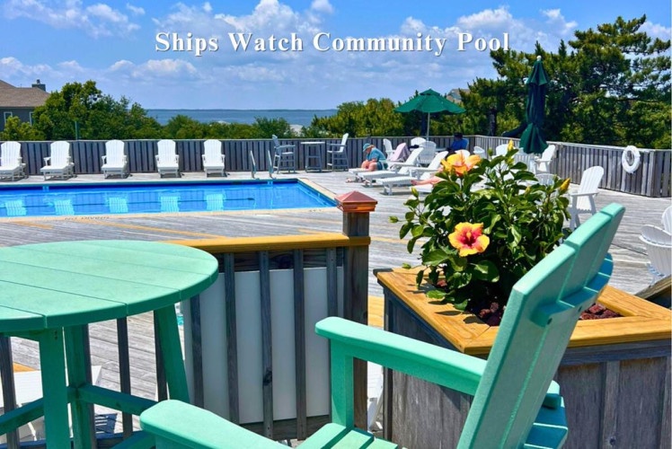 Relax by the sparkling community pool, where you can unwind on lounge chairs, soak up coastal breezes, and enjoy waterfront views framed by vibrant flowers and shaded seating areas.