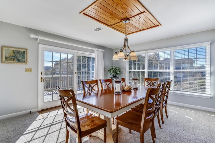 Gather around this inviting dining table where natural light pours through large windows, creating the perfect setting for your memorable meals together.