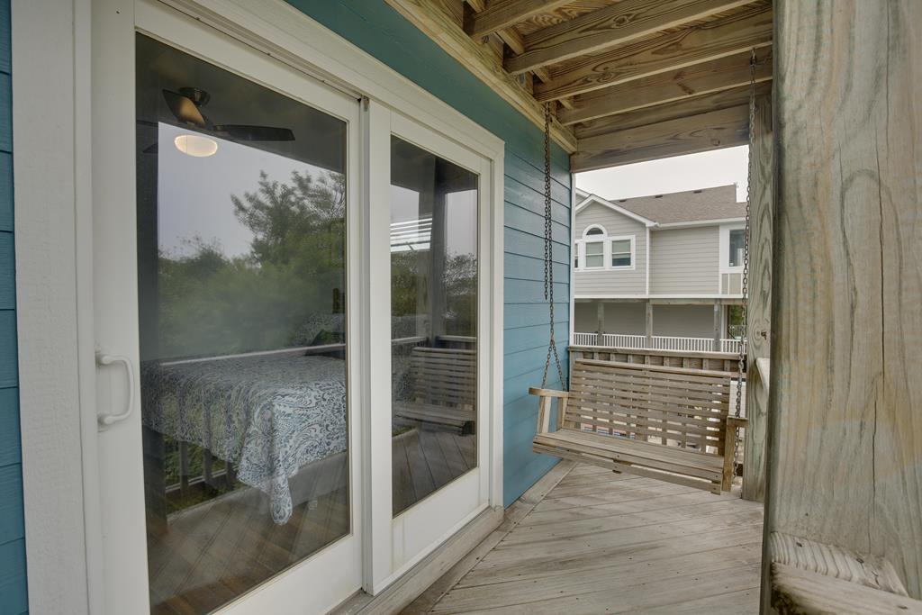 Step through sliding doors onto your private covered porch, where a wooden swing awaits for peaceful moments overlooking the quiet neighborhood.