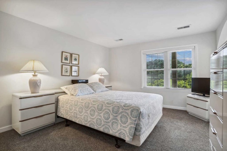 Unwind in your serene bedroom with soft natural light streaming through large windows, plush bedding, and elegant furnishings that create the perfect retreat for restful nights.