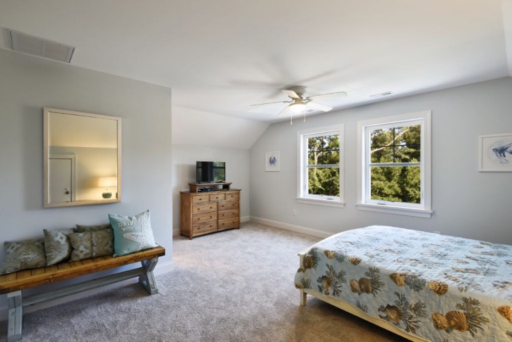 Your serene bedroom retreat features soft natural light, peaceful garden views, and a cozy ceiling fan to keep you comfortable throughout your stay.