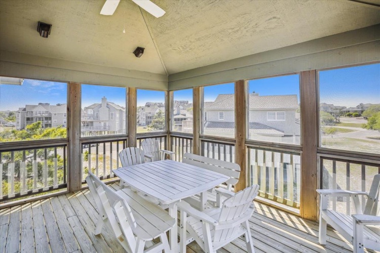 Your screened-in porch offers protected outdoor dining with sweeping neighborhood views, ceiling fan comfort, and a perfect spot to enjoy morning coffee or evening meals surrounded by natural light.