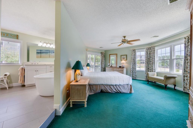 Relax in your spacious master suite with en-suite bathroom, private balcony, and abundant natural light. Coastal-inspired décor and ceiling fan create a breezy, peaceful retreat.