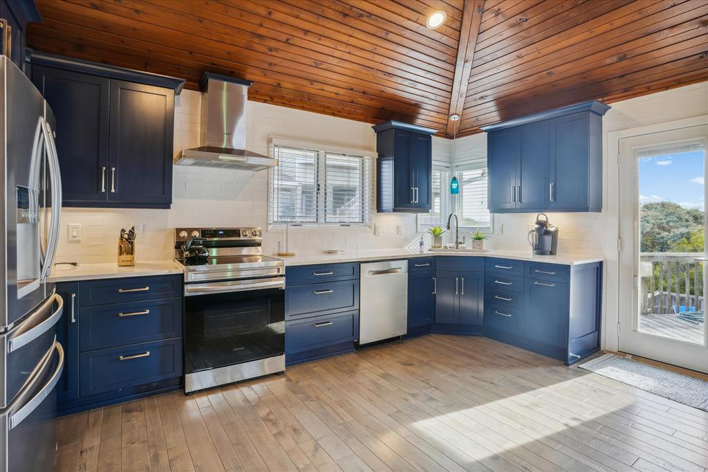 Prepare your meals in this stunning kitchen with navy cabinetry, stainless steel appliances, and warm wood tones creating an inviting atmosphere for your stay.
