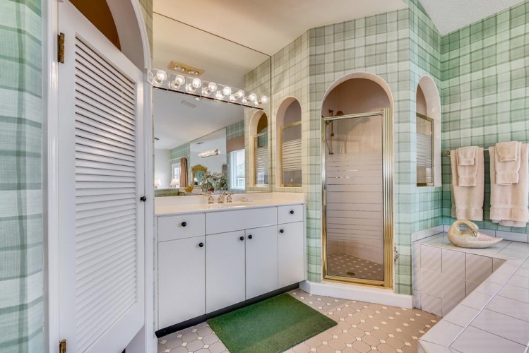 Step into your spacious bathroom with charming plaid tile, a bright vanity for your morning routine, and a refreshing walk-in shower waiting to wash away the day.
