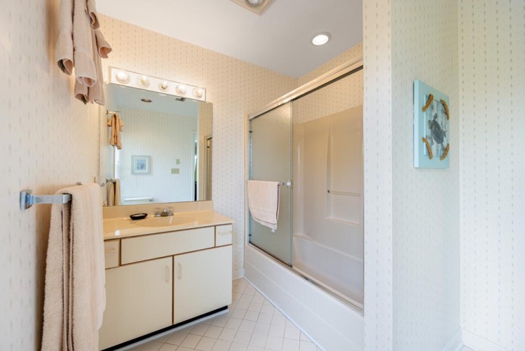 This updated bathroom features a spacious tub-shower combo and well-lit vanity area, giving you a bright and comfortable space to refresh during your stay.