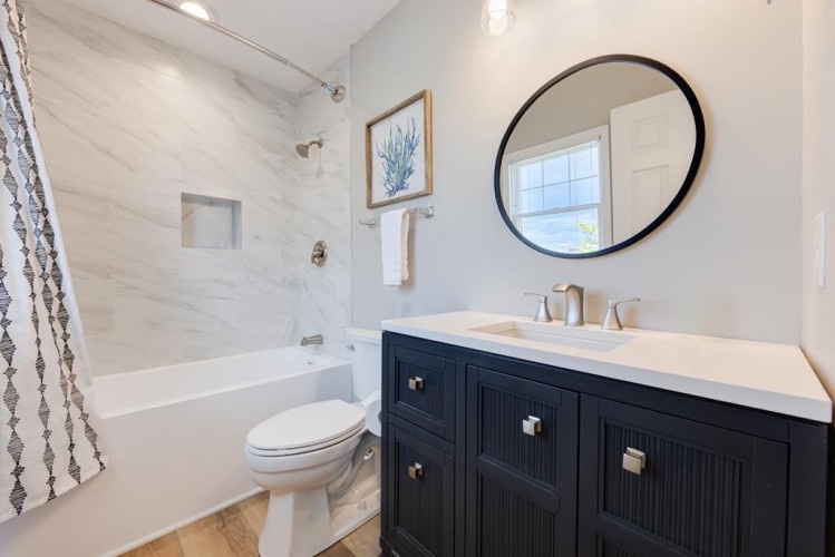 Freshen up in your coastal-chic bathroom with crisp white subway tiles, a sleek vanity, and a soaking tub where you can unwind after your adventures.