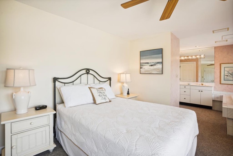 Sink into crisp white linens and unwind beneath the gentle breeze of ceiling fans. Your coastal retreat awaits with soothing décor and a spacious ensuite to refresh after beach days.