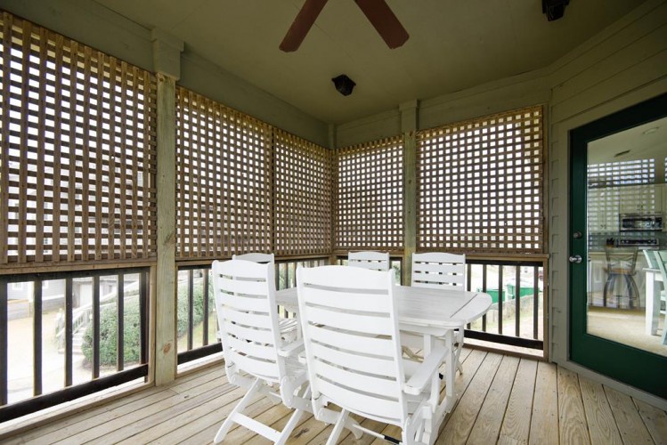 Your private screened porch invites you to unwind with morning coffee or evening conversations, cooled by the ceiling fan and filtered sunlight through lattice panels.