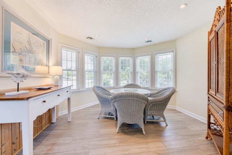 Natural light floods your private sitting area, where wicker chairs invite you to relax with a book or morning coffee while gazing at the peaceful views beyond.