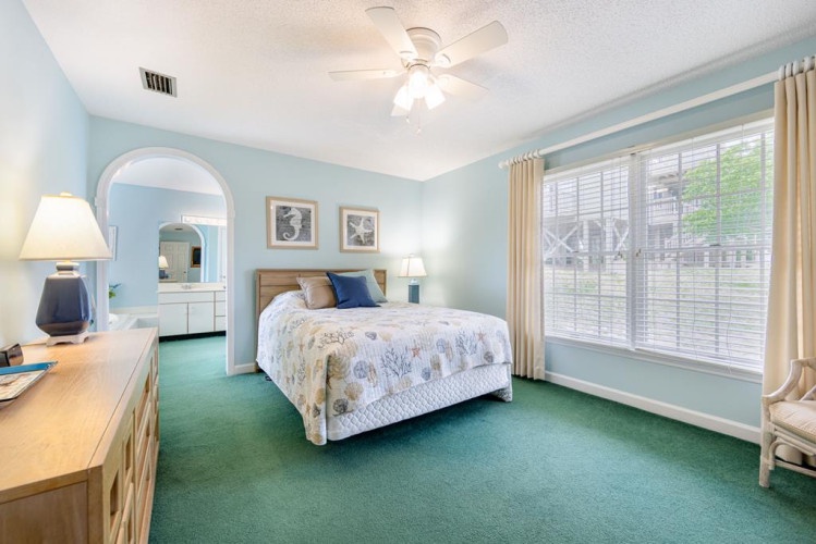 Sink into your plush bed in this serene, coastal-inspired retreat. Soft blues, natural light, and a ceiling fan create the perfect sanctuary for rest and relaxation.