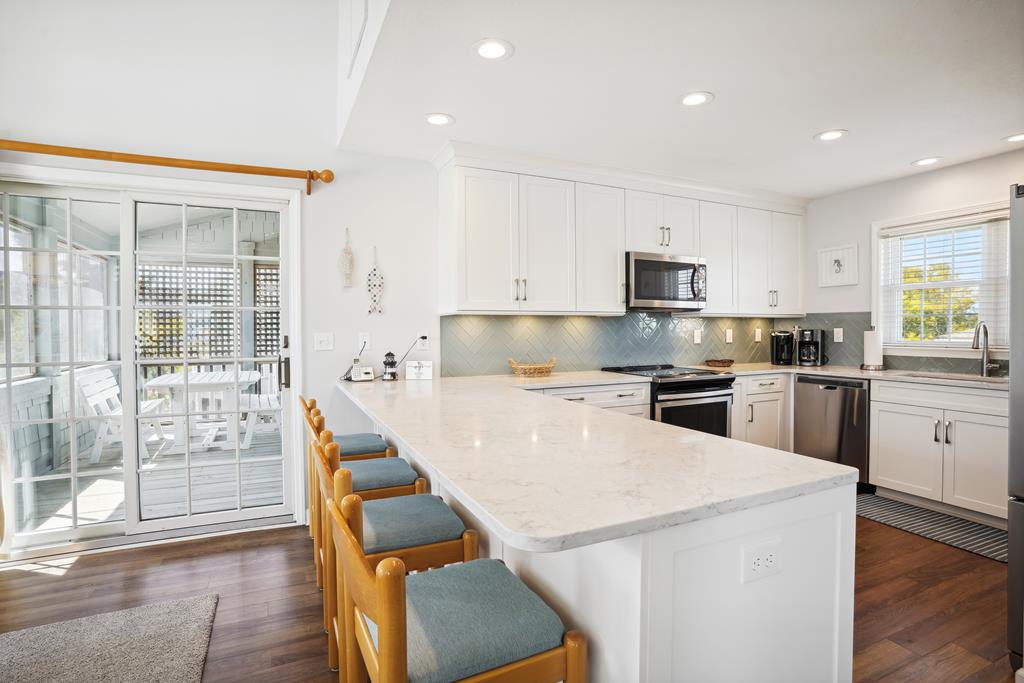Your bright, fully-equipped kitchen invites you to prepare meals together with gleaming white counters, modern appliances, and a spacious island with seating for casual dining or morning coffee.