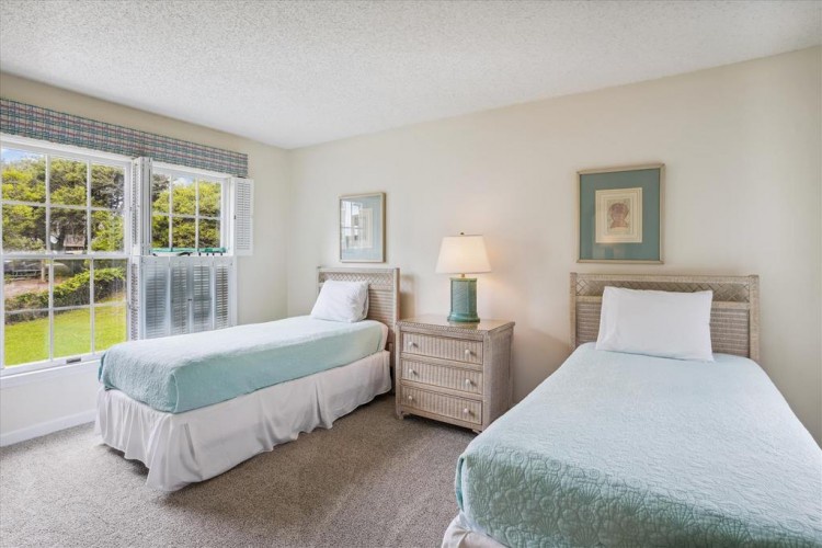 Wake up to sunlit mornings in your serene twin bedroom, where soft coastal hues and peaceful garden views create the perfect backdrop for restful nights and relaxed mornings.