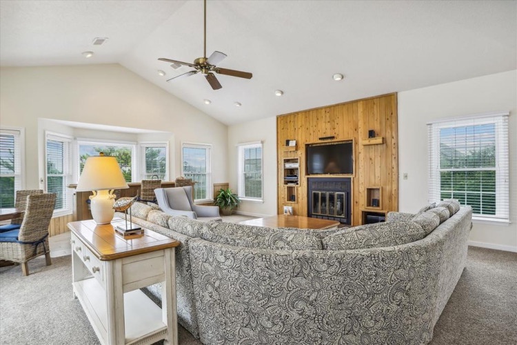 Relax in your spacious living area with vaulted ceilings, a cozy fireplace, and abundant natural light streaming through large windows. Perfect for unwinding after a day of adventures.