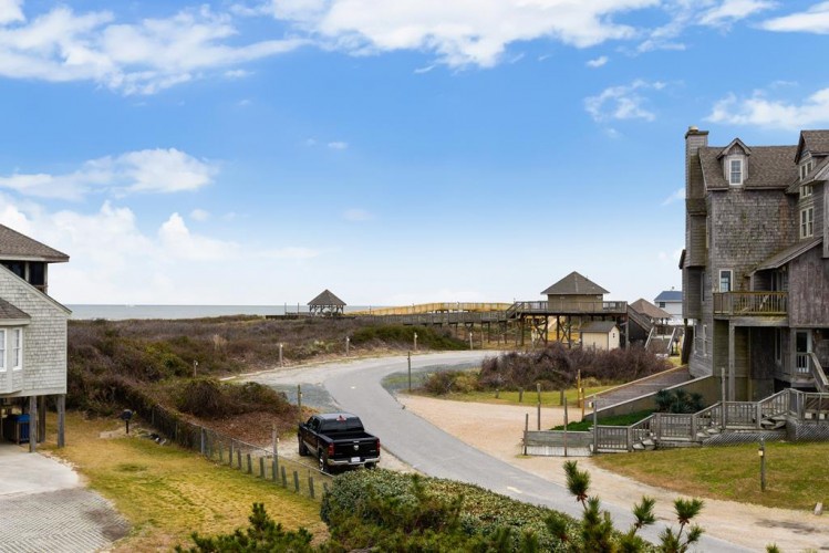 A coastal retreat featuring elevated beach houses with ocean views, nearby recreational boardwalk, and convenient parking access in a peaceful seaside neighborhood.