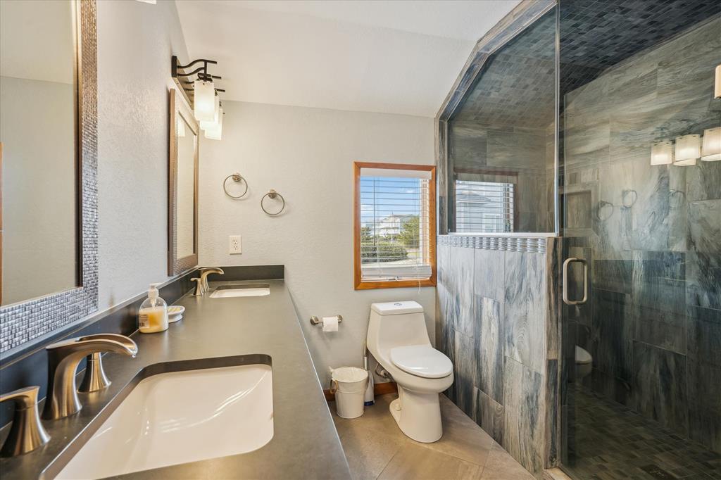 Step into your serene sanctuary with dual sinks, a stunning walk-in shower, and natural light streaming through the window—perfect for refreshing mornings and unwinding evenings.