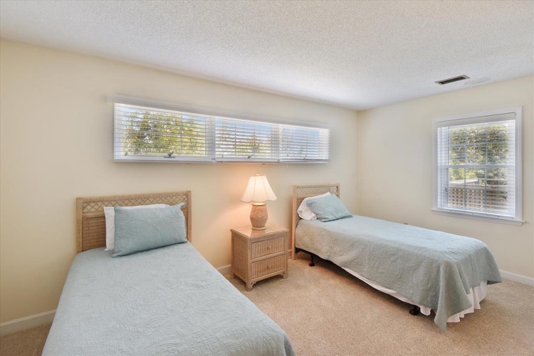 Your peaceful twin bedroom awaits with soft linens, warm coastal touches, and natural light streaming through the windows—ideal for restful mornings or quiet afternoons.