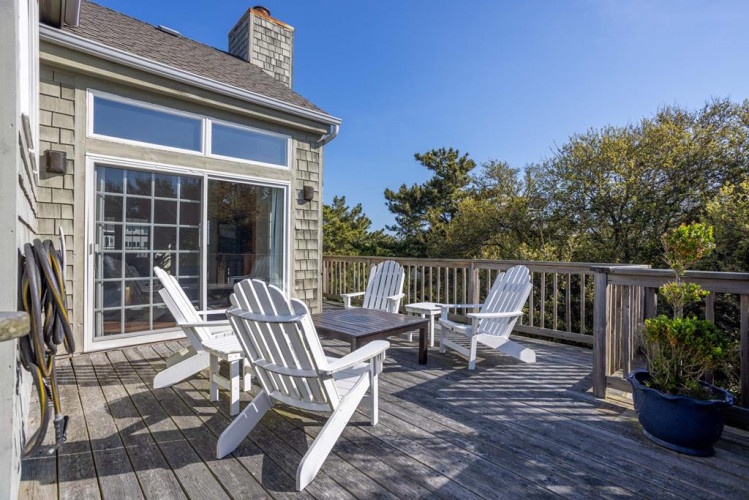 Spacious deck with Adirondack chairs surrounded by lush trees, perfect for morning coffee or sunset views. Natural privacy creates your peaceful outdoor retreat.