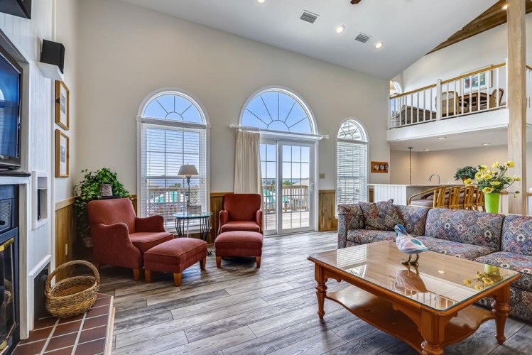 Relax in this bright living room with soaring ceilings, cozy seating, and graceful arched windows that flood the space with natural light and offer views.