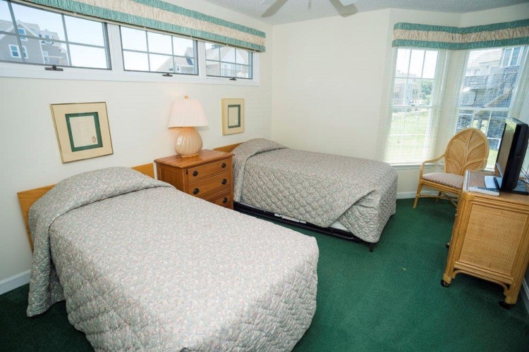 Drift off to sleep in this cozy twin bedroom, where soft natural light and classic coastal decor create your perfect retreat after a day of exploring.