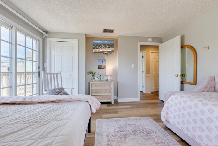 Your bright, spacious bedroom with soft pink accents and large windows letting in natural light—a peaceful retreat after a day of adventure.