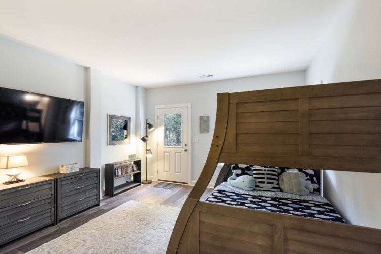 Your private retreat features a striking custom bunk with ample storage, a flat-screen TV for movie nights, and plenty of natural light streaming through the front door.