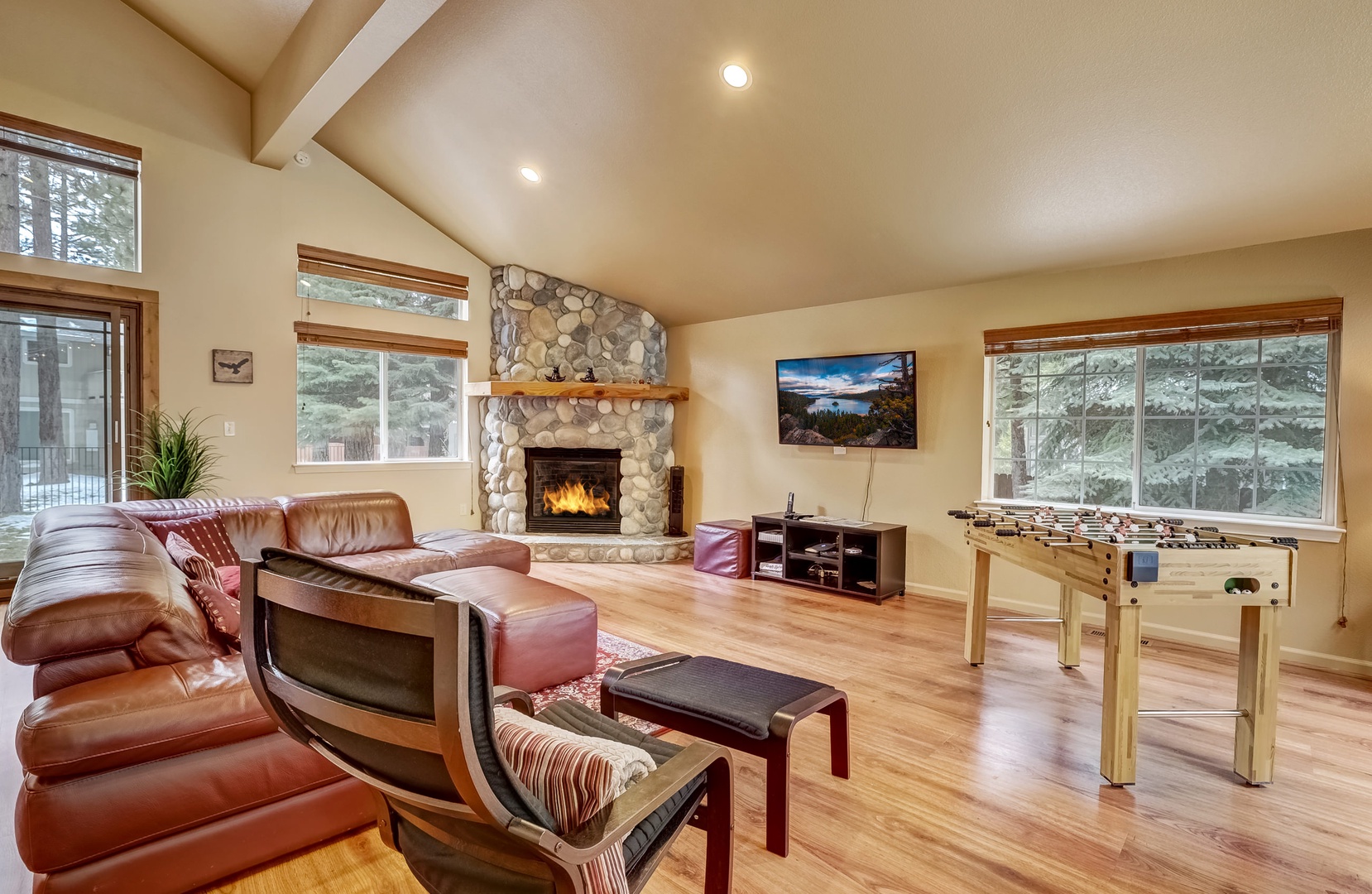 Open living space with Smart TV, foosball table, gas fireplace, and deck access