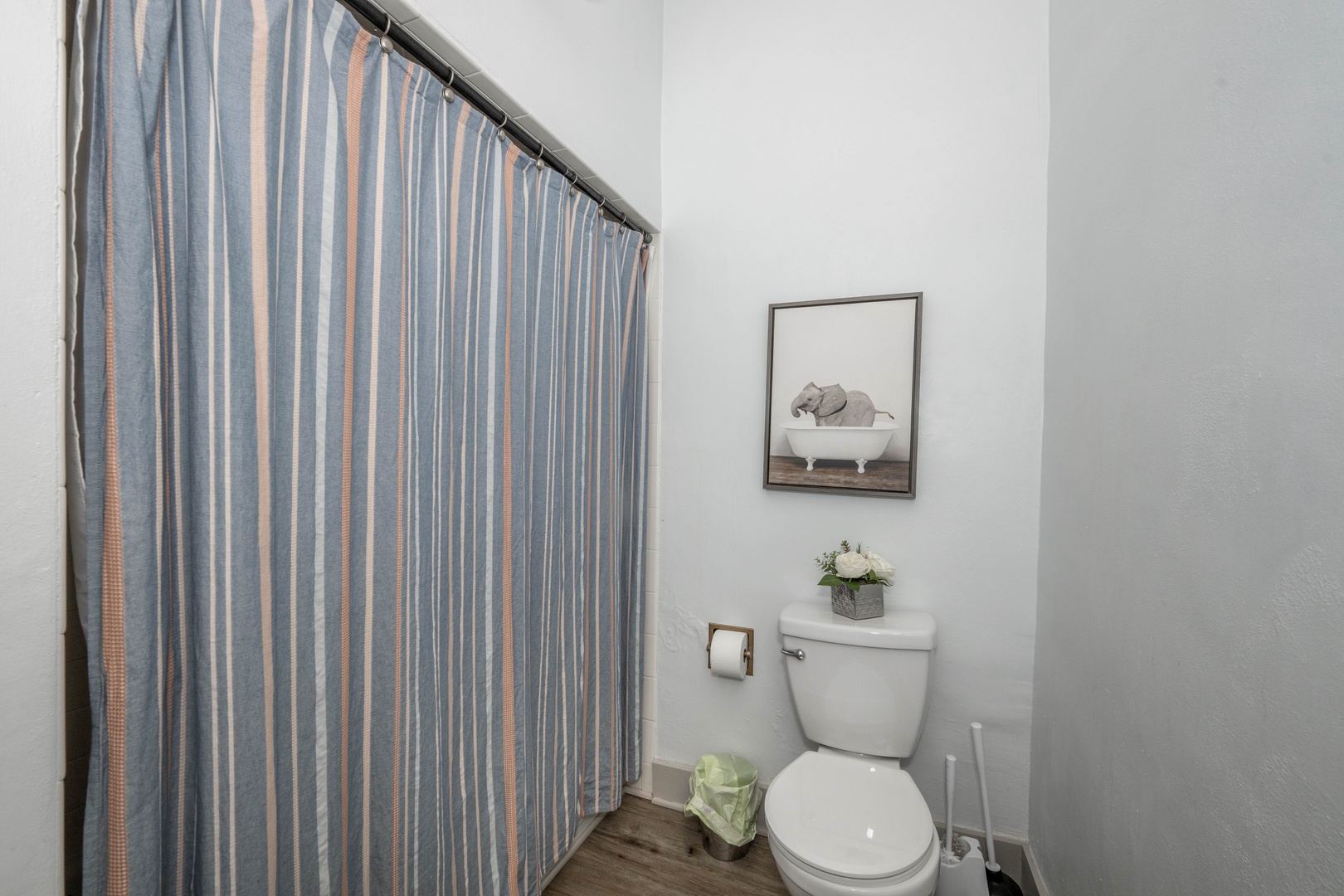 The full bathroom features a sleek single vanity & shower/tub combo