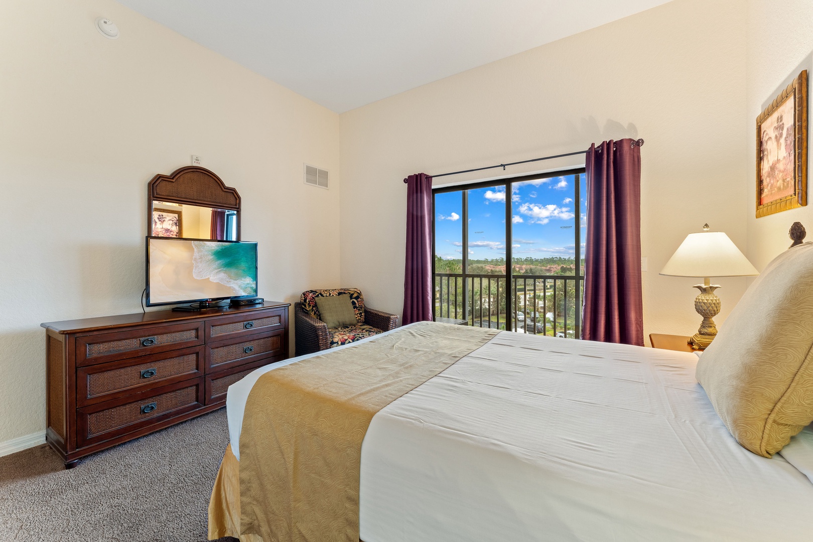 Recharge in the queen bedroom, featuring a TV & balcony access