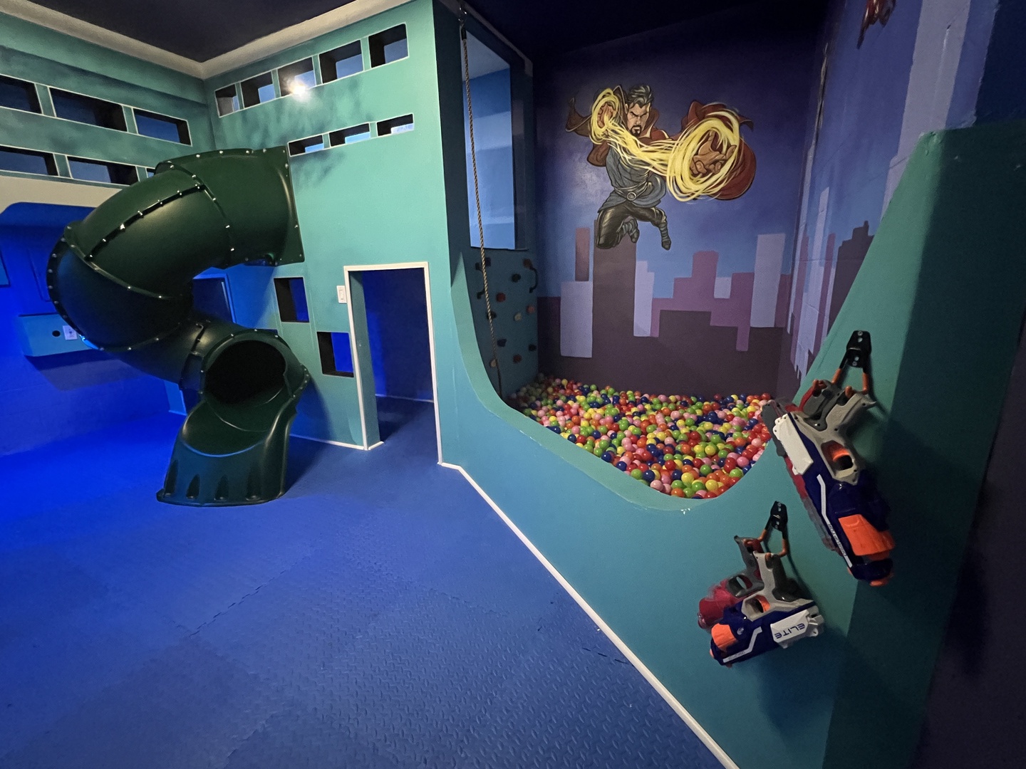 Avengers garage playroom with slide, ball pit, and rock climbing wall