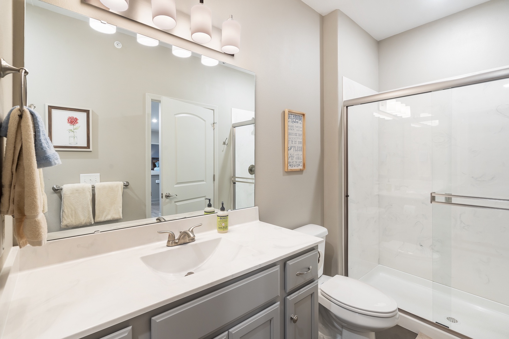 This serene ensuite offers a single vanity & glass shower