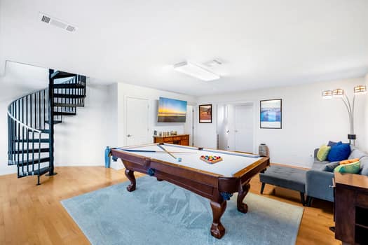 The game room offers a pool table, queen sofa sleeper, and Smart TV
