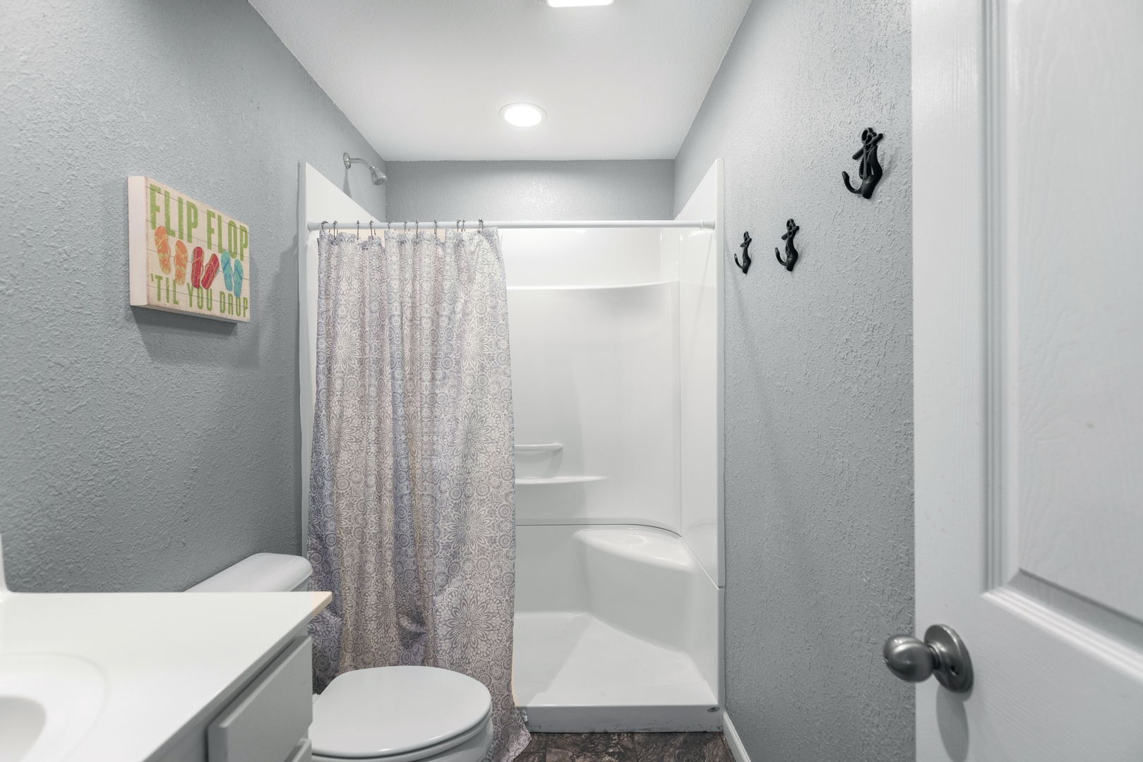 The guest house bathroom features a single vanity and a walk-in shower