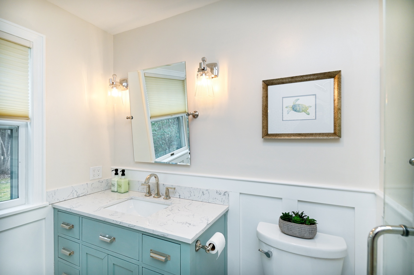 Harbor View’s chic ensuite bath includes a single vanity & luxe glass shower