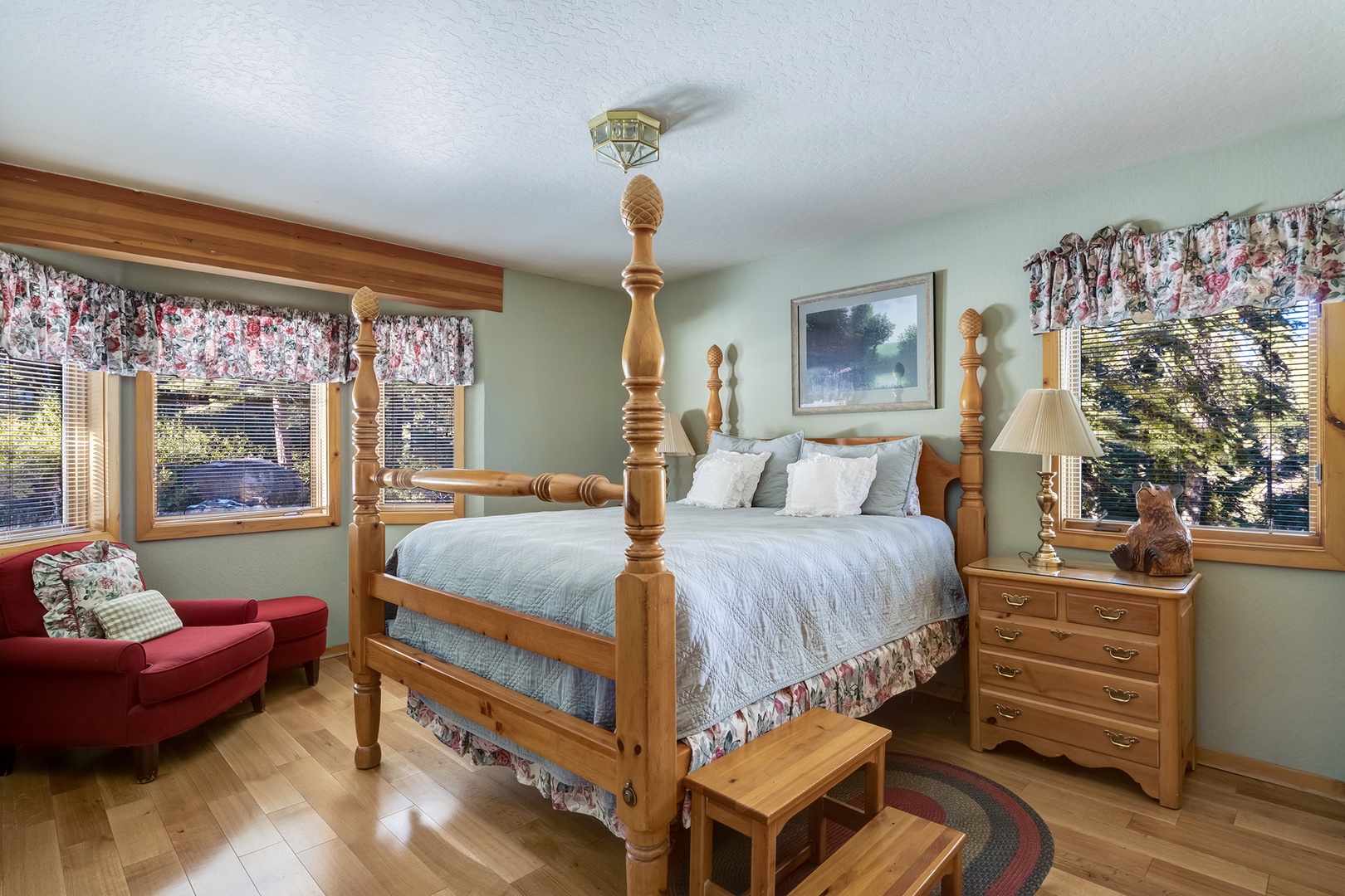 This bedroom retreat features a comfortable queen-size bed and a cozy reading chair