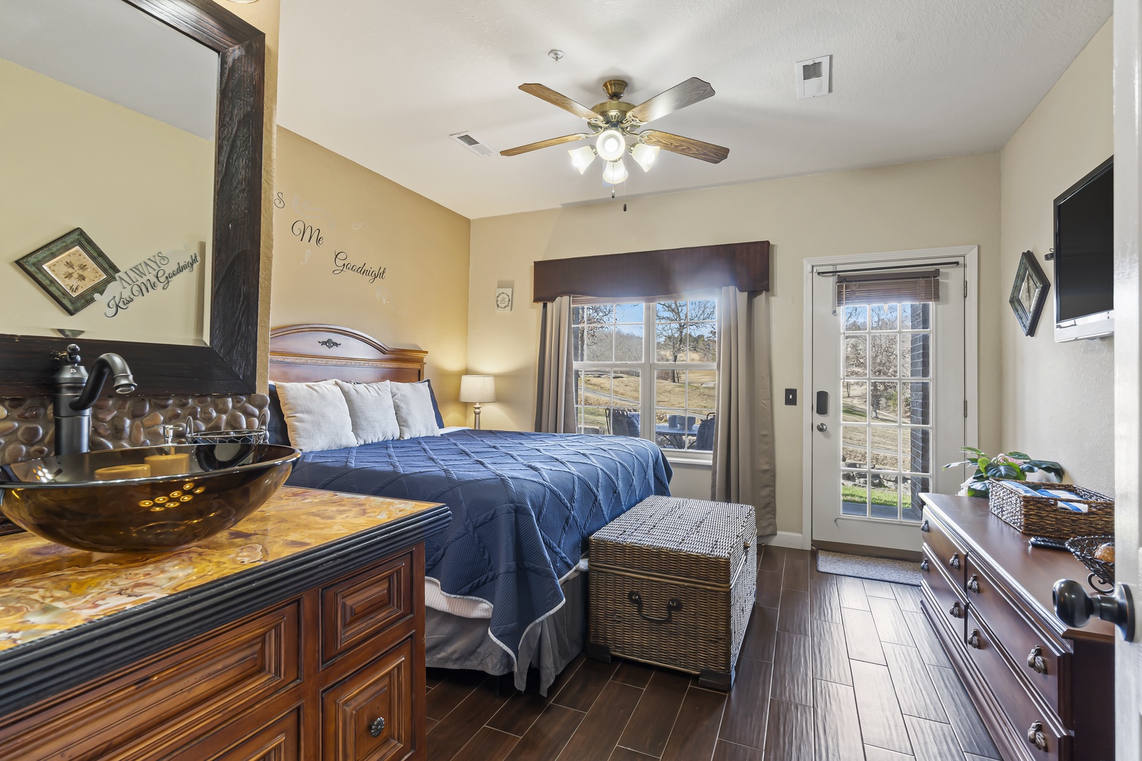 The bedroom includes a regal king bed, Smart TV, & patio access