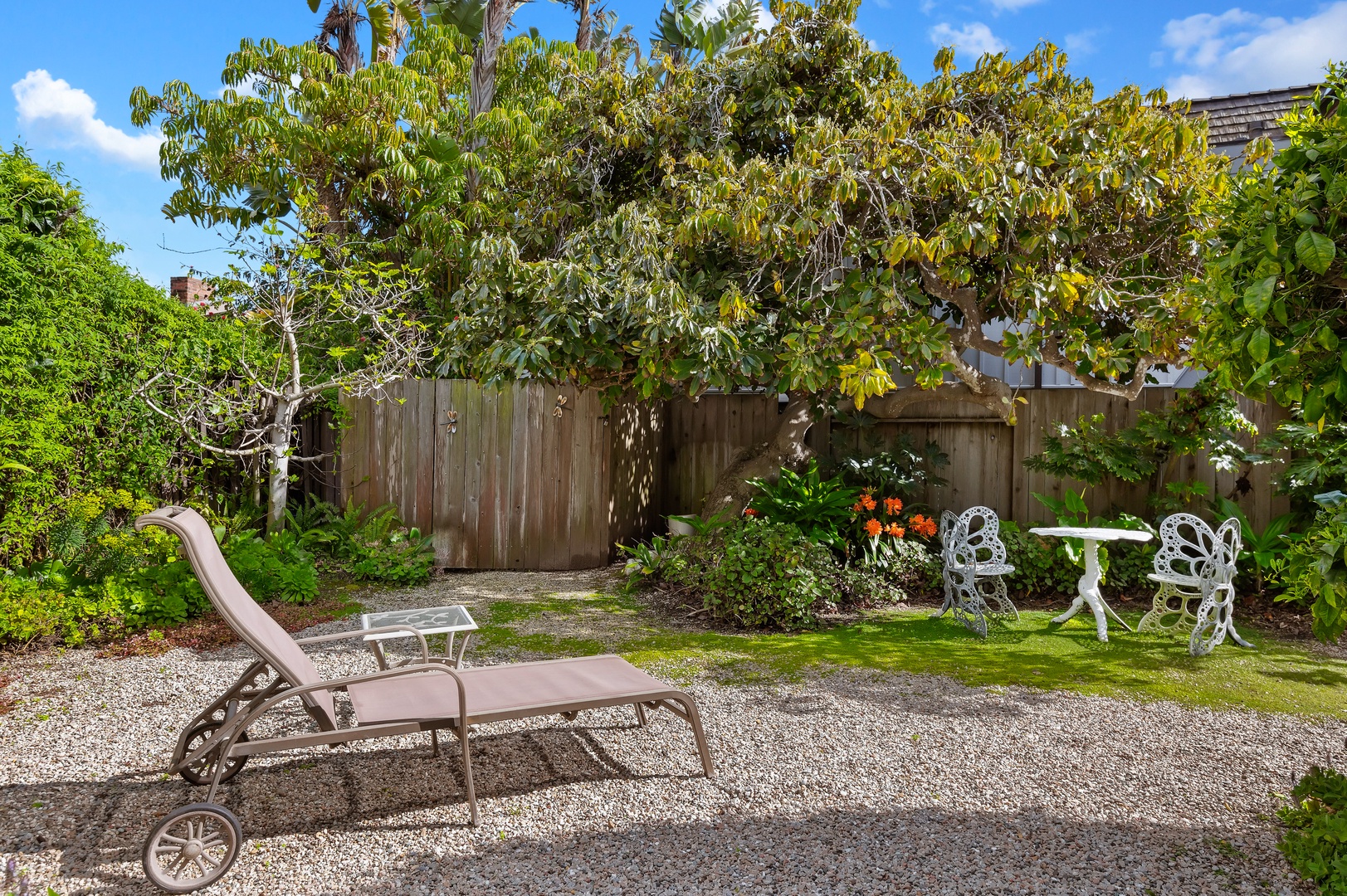 Lounge in the sunshine surrounded by the fruit trees and abundant flowers of this home’s gardens