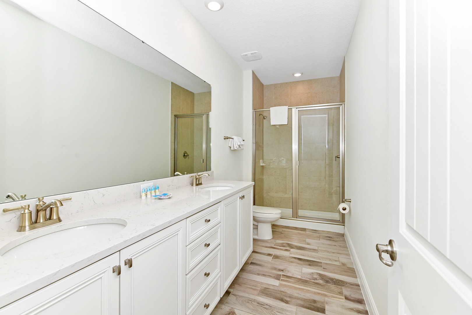 Master ensuite bath with double vanity and walk-in shower with glass doors